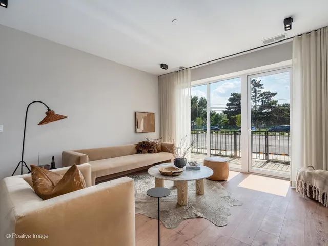 a living room with furniture a table and kitchen view