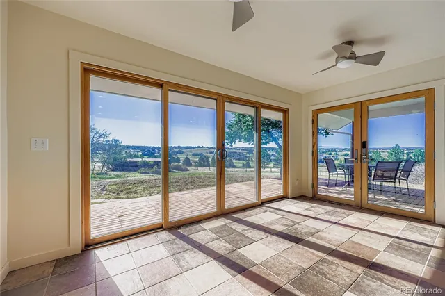 a view of an empty room with chandelier fan