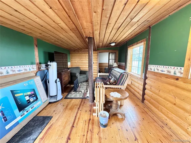 a living room with furniture a flat screen tv and a large window