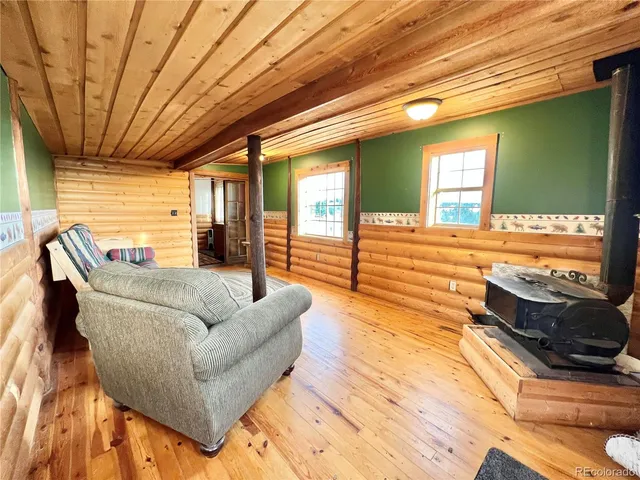 a living room with furniture floor to ceiling window and wooden floor