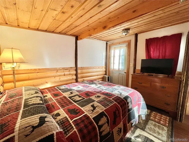 a bedroom with a bed and a flat screen tv