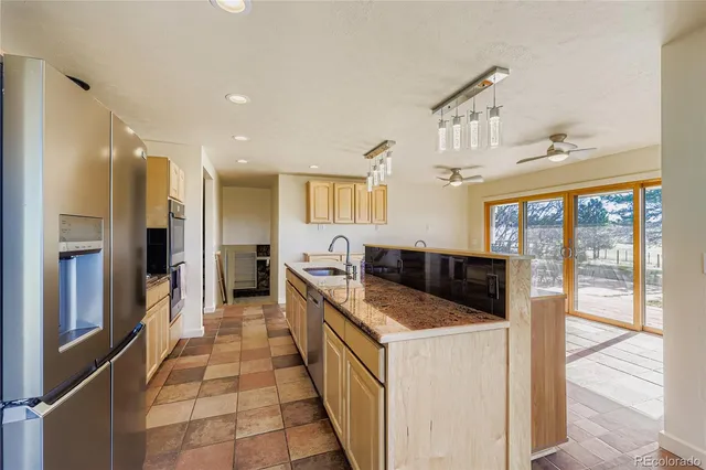 a kitchen with stainless steel appliances granite countertop a sink and a refrigerator