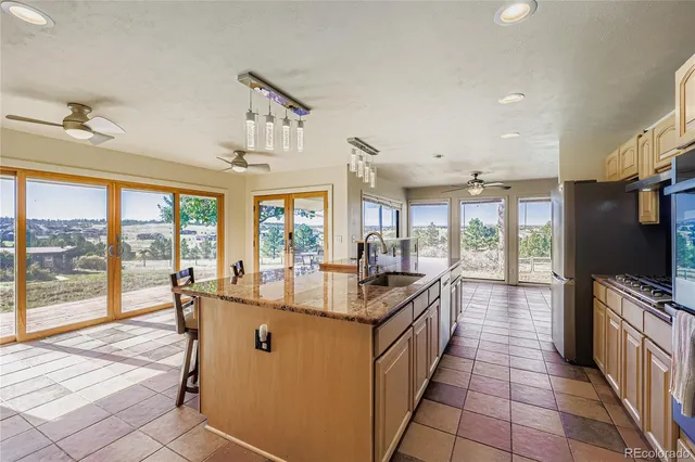 a dining hall with stainless steel appliances granite countertop a sink and a refrigerator