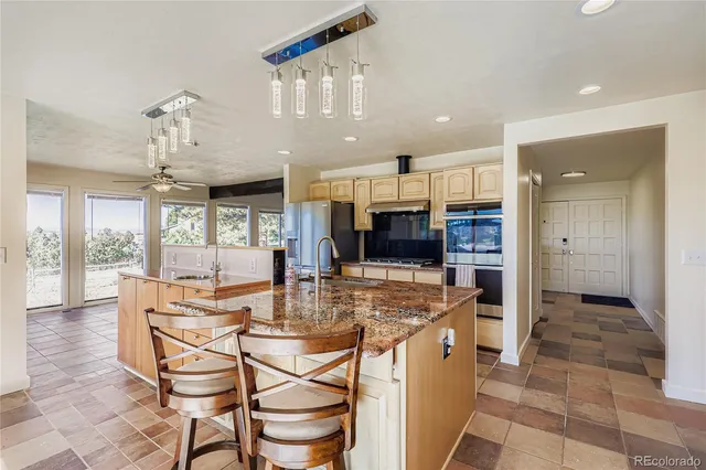 a kitchen with stainless steel appliances kitchen island granite countertop a sink and cabinets