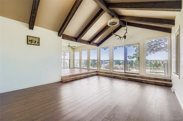 a view of a room with wooden floor and door