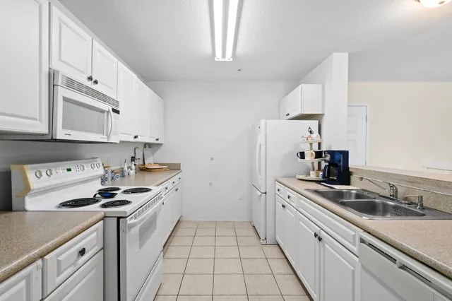 a kitchen with stainless steel appliances a sink stove and white cabinets