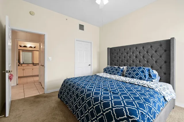 a bedroom with a large bed and painting on the wall