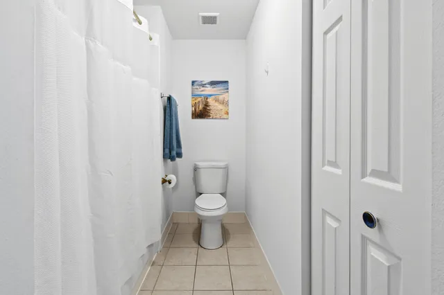 a bathroom with a toilet and a shower curtain