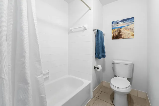 a white toilet sitting next to a white sink and vanity