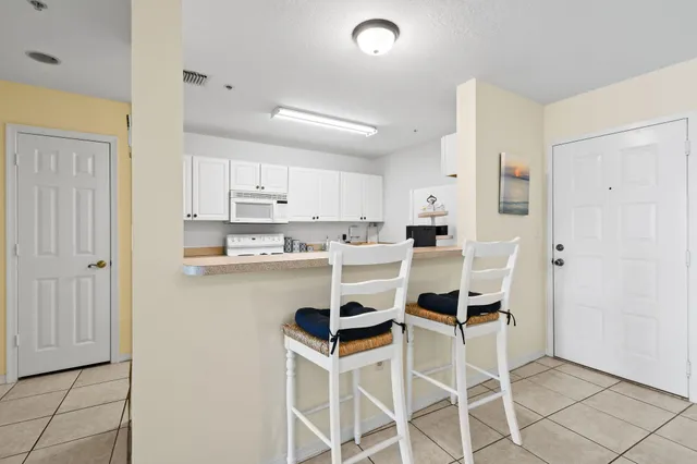 a kitchen with a refrigerator and white cabinets