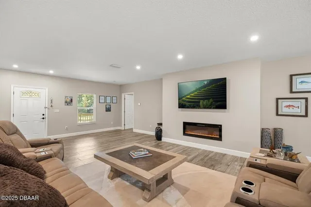 a living room with furniture a flat screen tv and a fireplace
