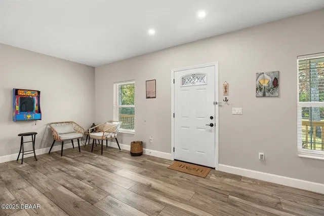 a living room with furniture wooden floor and windows