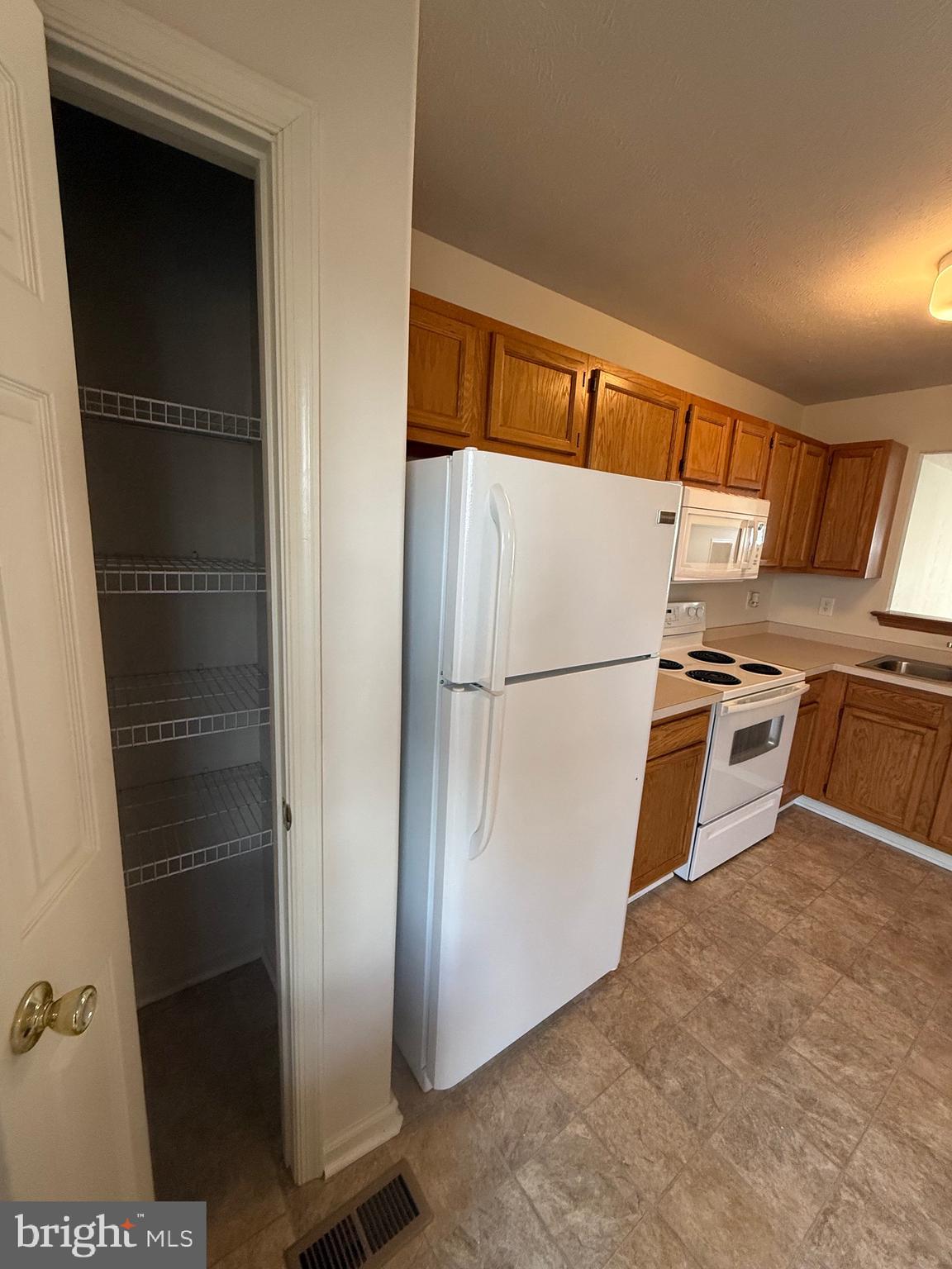 294 Mike Drive Elkton, MD 21921 - Photo 19 of 61 a view of a refrigerator in kitchen and an empty room