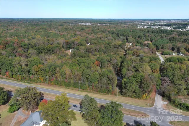 an aerial view of residential houses with outdoor space and trees