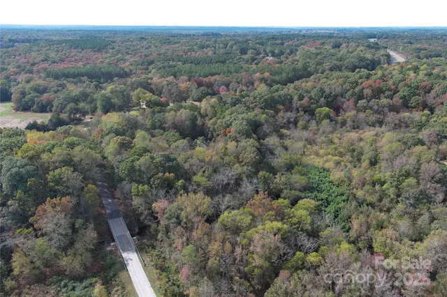 an aerial view of residential houses with outdoor space and trees