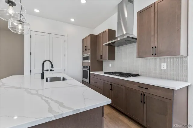 a kitchen with stainless steel appliances granite countertop a white stove top oven a sink and dishwasher