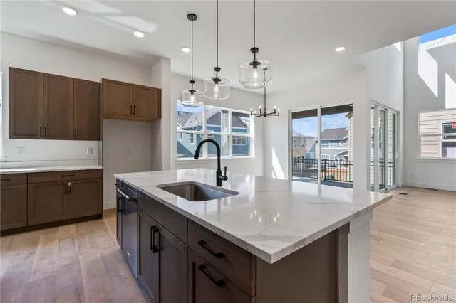 a kitchen with stainless steel appliances granite countertop a sink a refrigerator and wooden cabinets