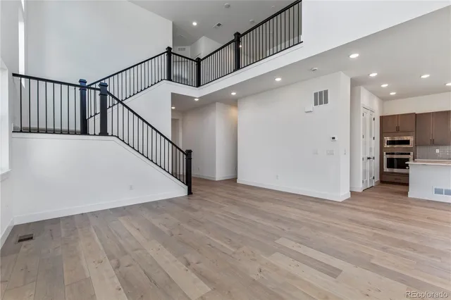 a view of a hallway with wooden floor and staircase
