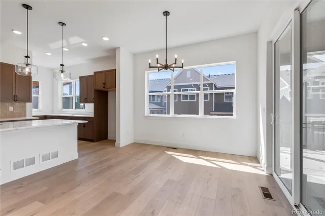 a kitchen with stainless steel appliances granite countertop a refrigerator a oven and a wooden floors