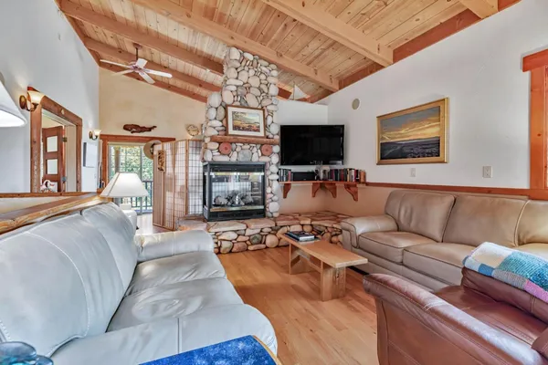 a living room with furniture a flat screen tv and a fireplace