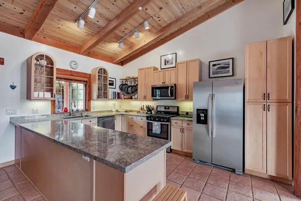a kitchen with stainless steel appliances granite countertop a refrigerator a sink and dishwasher