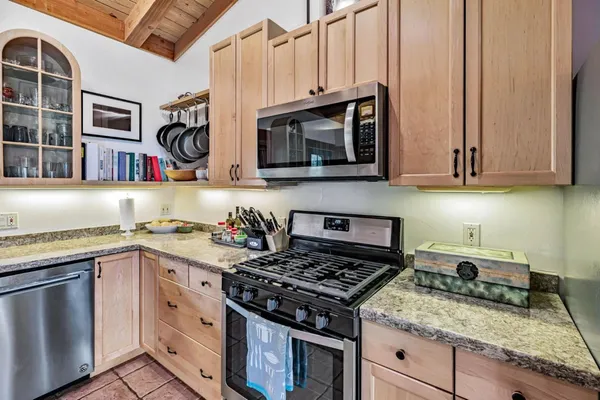 a kitchen with stainless steel appliances granite countertop a stove and a microwave