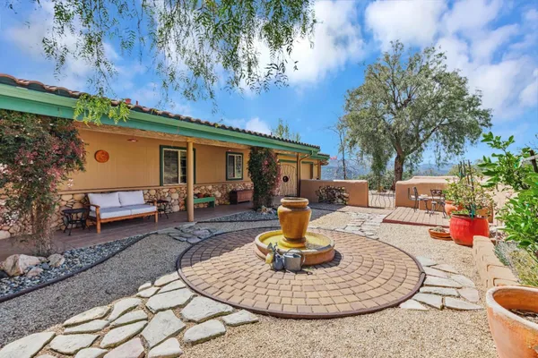 a view of a house with backyard water fountain and sitting area