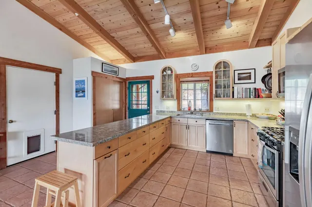 a bedroom with a bed a chair and next to a window