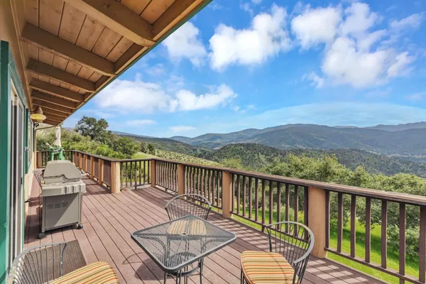 a view of a balcony with mountain view and wooden floor