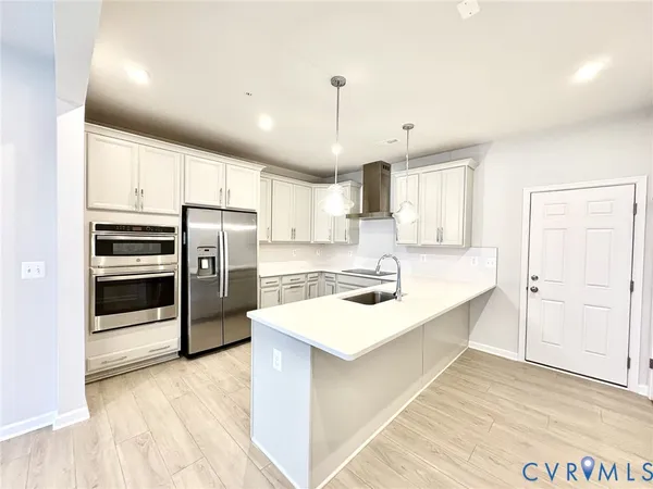 a kitchen with refrigerator cabinets and wooden floor