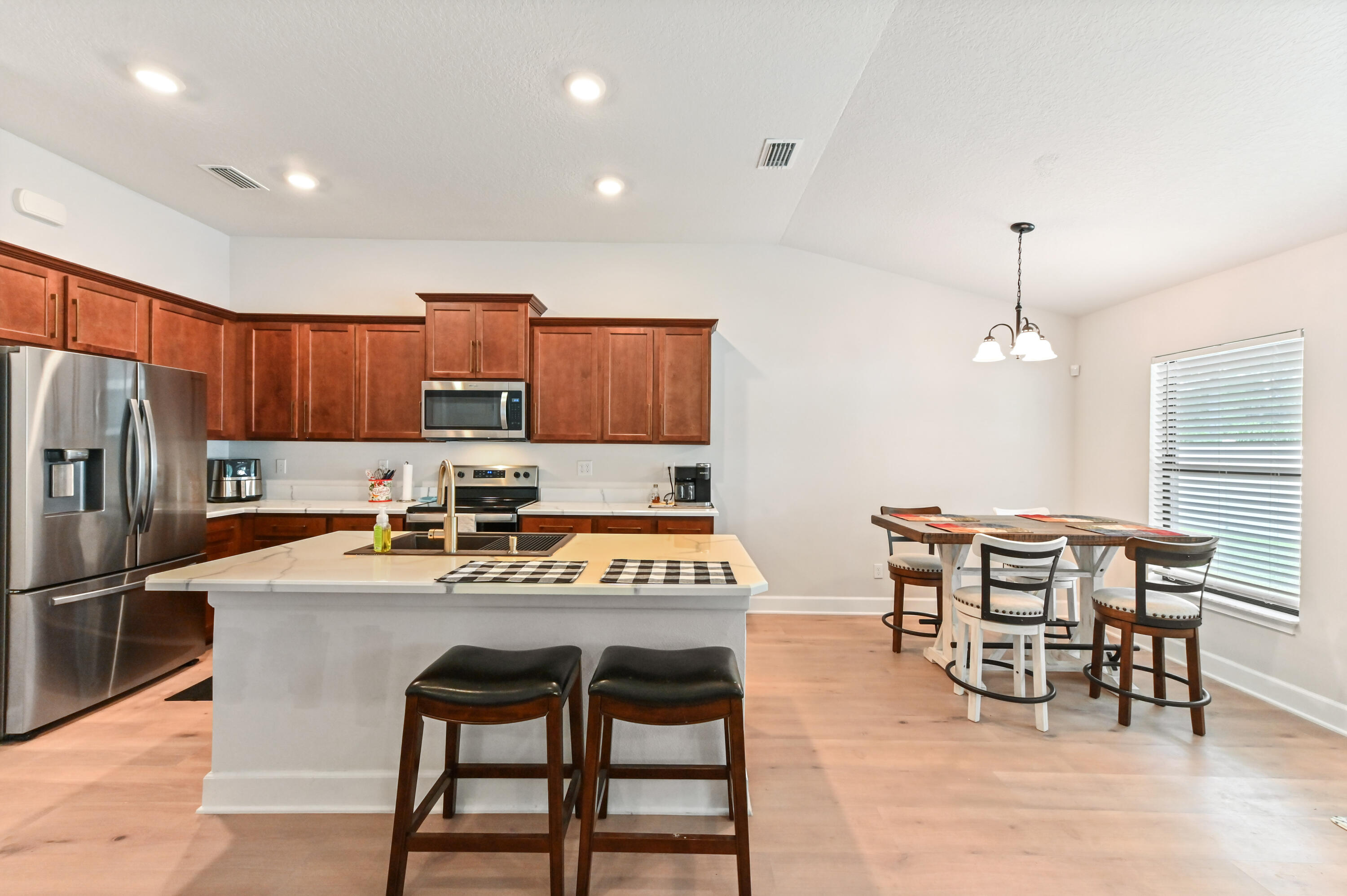 5352 Lugo Street Fort Pierce, FL 34951 - Photo 13 of 44 a kitchen with granite countertop a dining table chairs and refrigerator