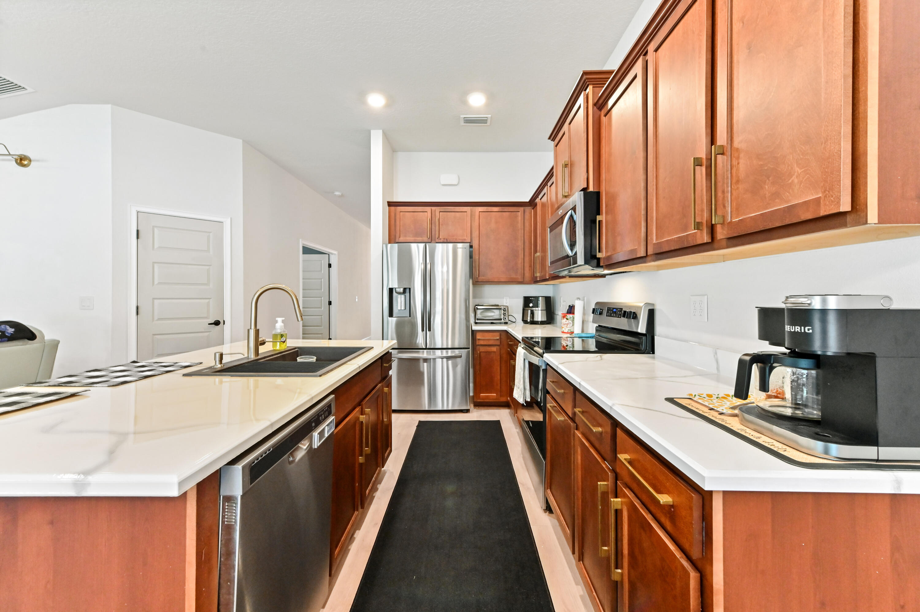 5352 Lugo Street Fort Pierce, FL 34951 - Photo 15 of 44 a kitchen with stainless steel appliances granite countertop a sink a stove and a refrigerator