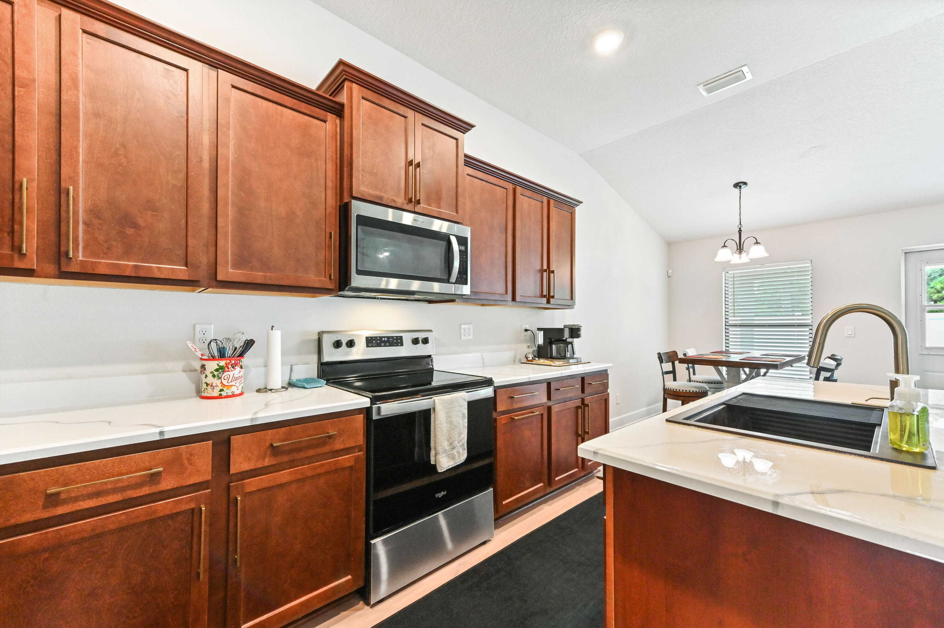 5352 Lugo Street Fort Pierce, FL 34951 - Photo 16 of 44 a kitchen with stainless steel appliances granite countertop a sink stove microwave and refrigerator