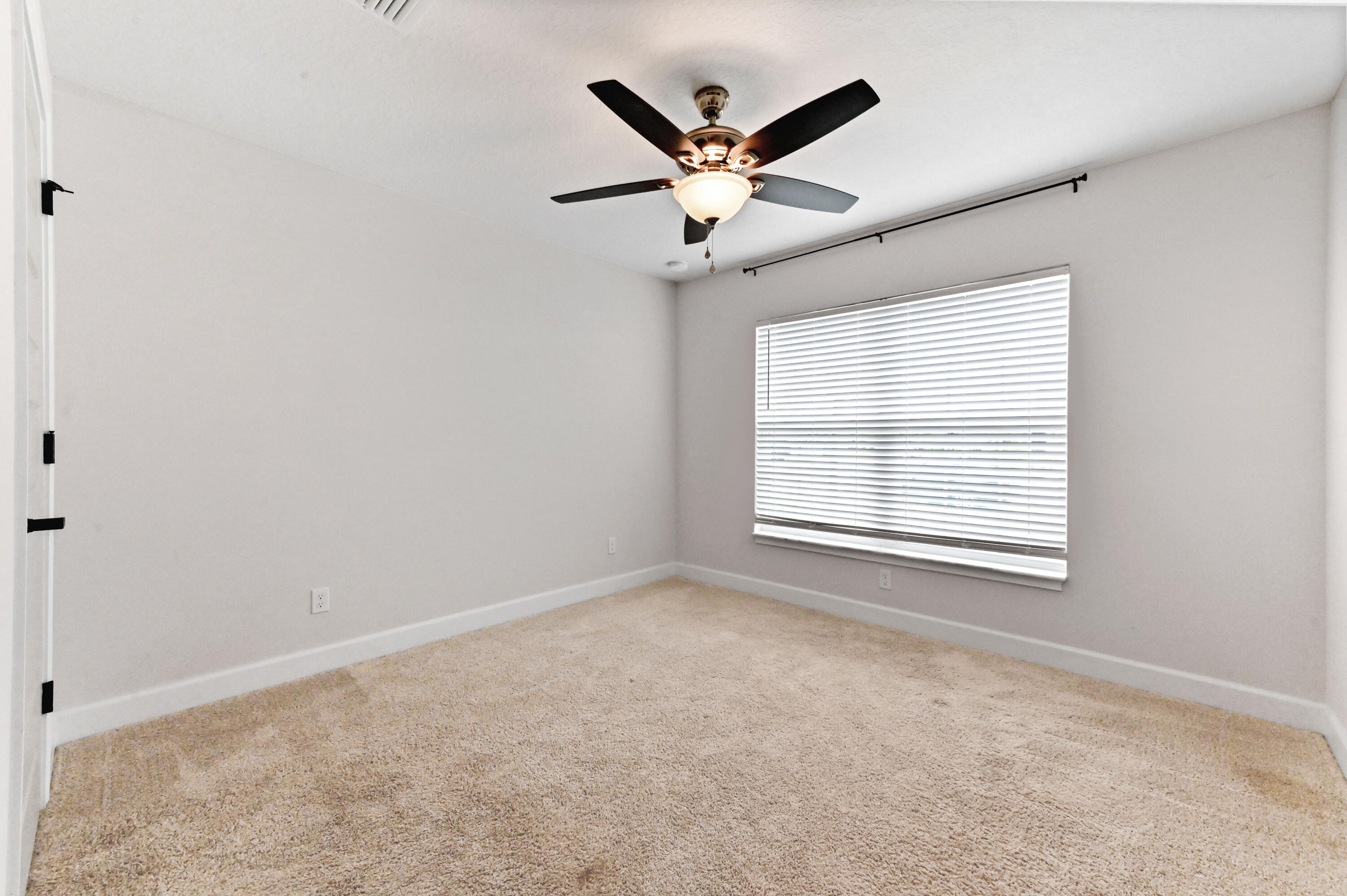 5352 Lugo Street Fort Pierce, FL 34951 - Photo 22 of 44 an empty room with ceiling fan and windows