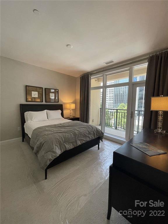 230 South Tryon Street, Unit 508 Charlotte, NC 28202 - Photo 13 of 24 a bedroom with a bed window and a couch
