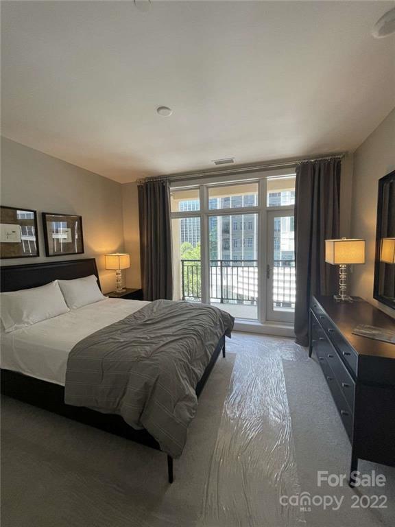 230 South Tryon Street, Unit 508 Charlotte, NC 28202 - Photo 14 of 24 a spacious bedroom with a large bed and a large window