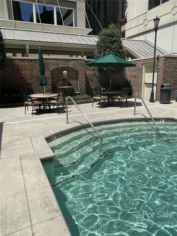 230 South Tryon Street, Unit 508 Charlotte, NC 28202 - Photo 23 of 24 a view of a patio with table and chairs a barbeque