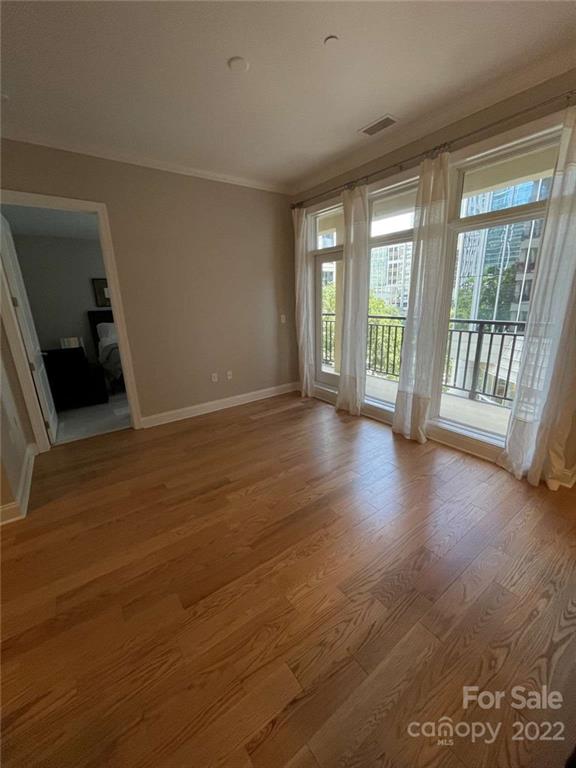 230 South Tryon Street, Unit 508 Charlotte, NC 28202 - Photo 6 of 24 a view of an empty room with wooden floor and a window