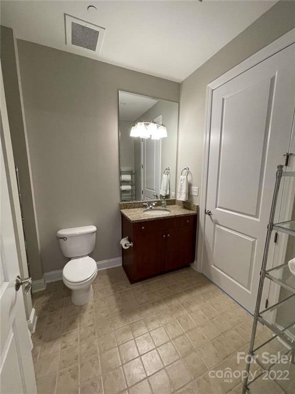 230 South Tryon Street, Unit 508 Charlotte, NC 28202 - Photo 9 of 24 a bathroom with a sink toilet and mirror