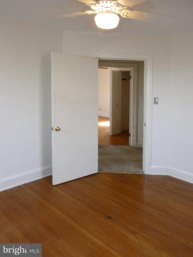 6216 Tramore Road Baltimore, MD 21214 - Photo 13 of 30 a view of a room with wooden floor and white walls