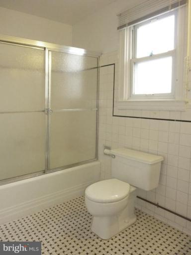 6216 Tramore Road Baltimore, MD 21214 - Photo 14 of 30 a bathroom with a toilet a window and a shower
