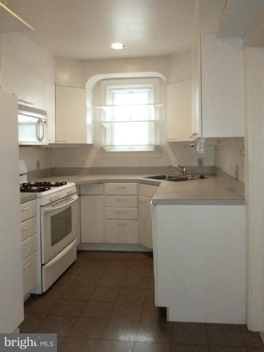6216 Tramore Road Baltimore, MD 21214 - Photo 16 of 30 a kitchen with a sink stove and microwave