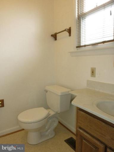 6216 Tramore Road Baltimore, MD 21214 - Photo 22 of 30 a white toilet sitting next to a bathroom sink