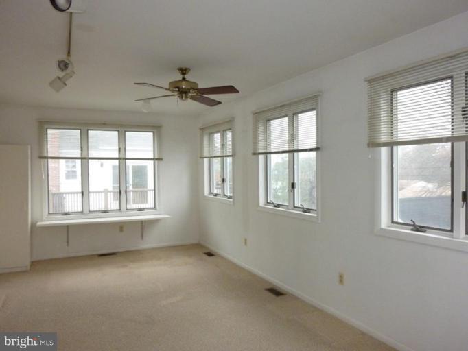 6216 Tramore Road Baltimore, MD 21214 - Photo 23 of 30 an empty room with chandelier fan and windows