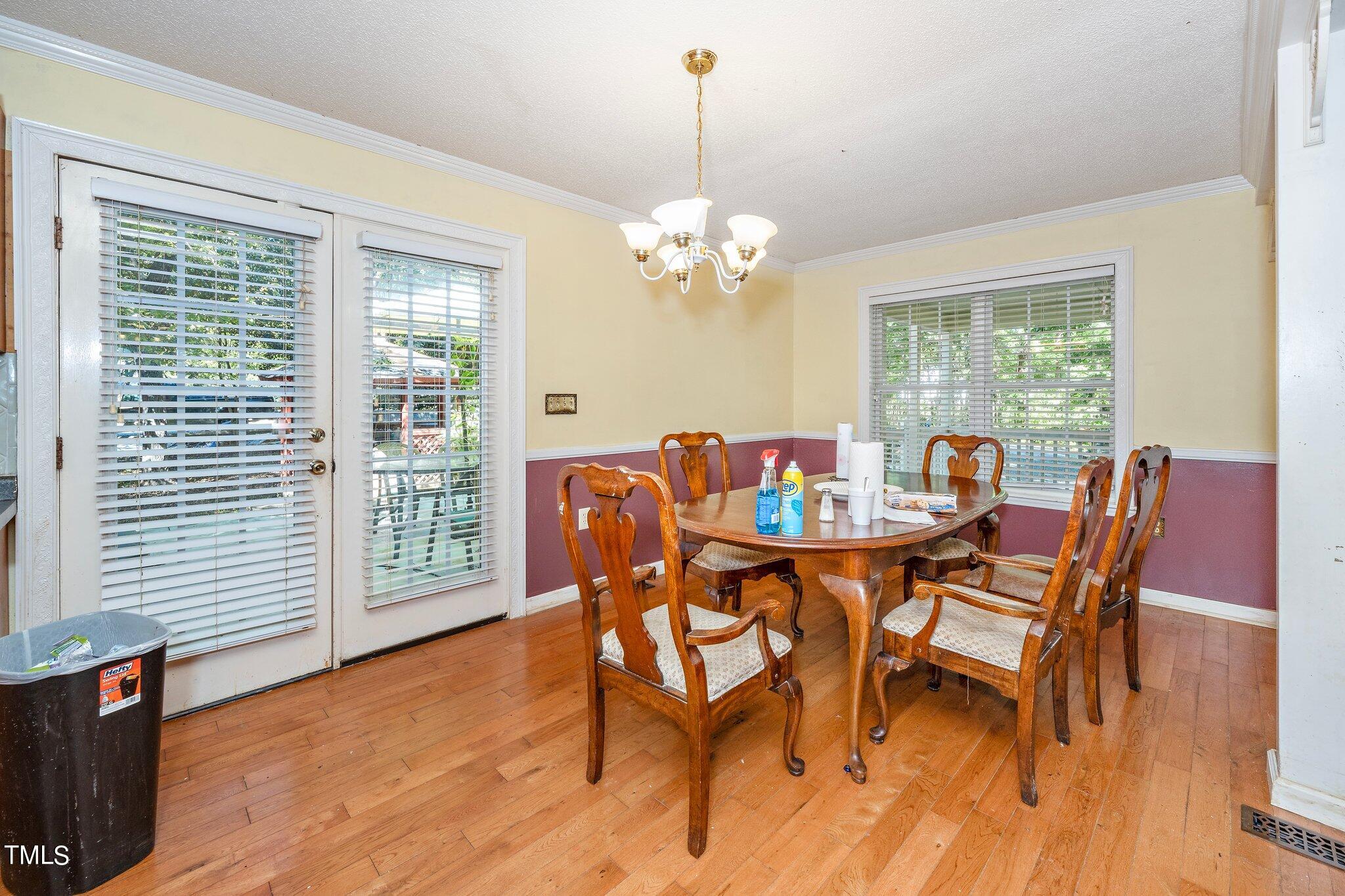 2514 Gemena Road Chapel Hill, NC 27516 - Photo 8 of 21 a dining room with furniture a chandelier and wooden floor
