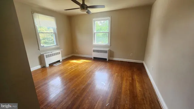 an empty room with wooden floor and a window