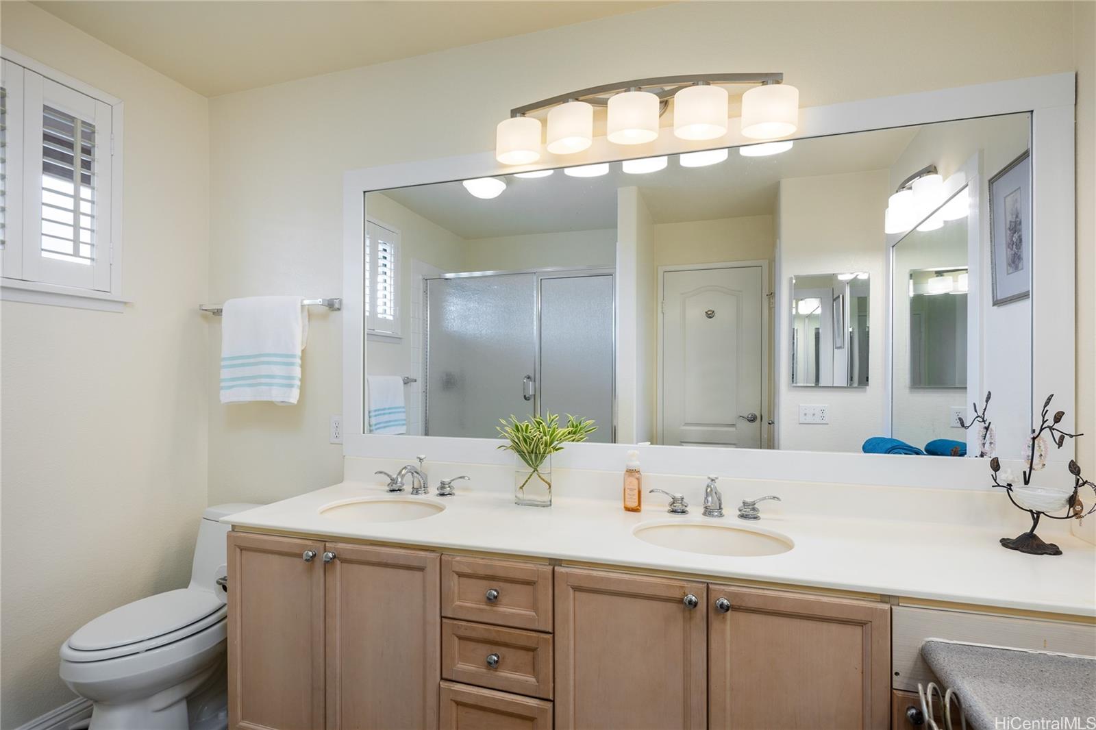 95-210 Kuauna Place Mililani, HI 96789 - Photo 14 of 25 a bathroom with a granite countertop sink a toilet and a mirror