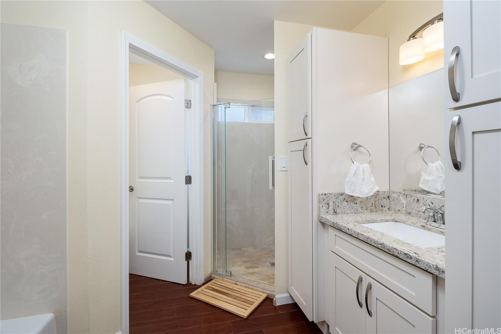 95-210 Kuauna Place Mililani, HI 96789 - Photo 16 of 25 a bathroom with a granite countertop sink two mirror and shower