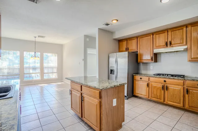 a kitchen with stainless steel appliances granite countertop a stove a sink and a refrigerator