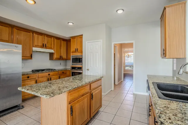 a kitchen with granite countertop a sink and a stove